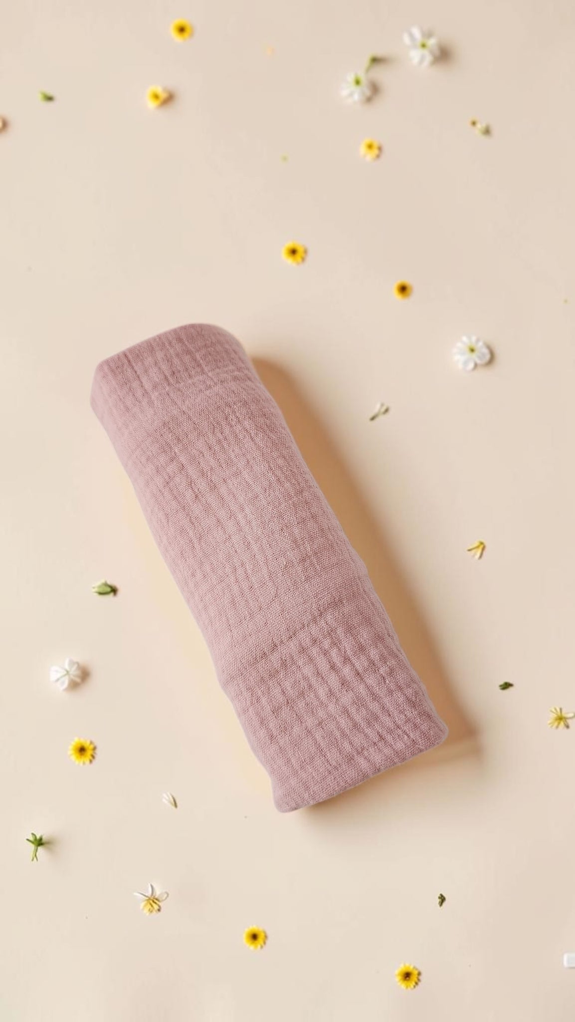 Cloudy Cotton dusty rose organic muslin baby swaddle wrap with soft breathable texture on a floral background